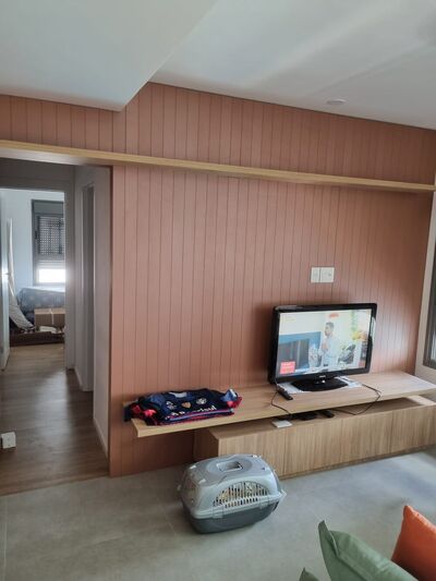 Mooca — sala com painel ripado e TV