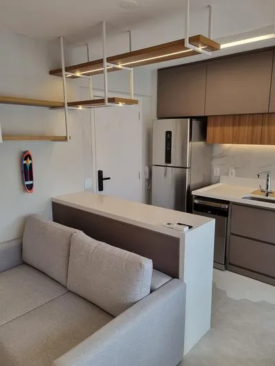 Studio Pinheiros: sala com sofá e iluminação